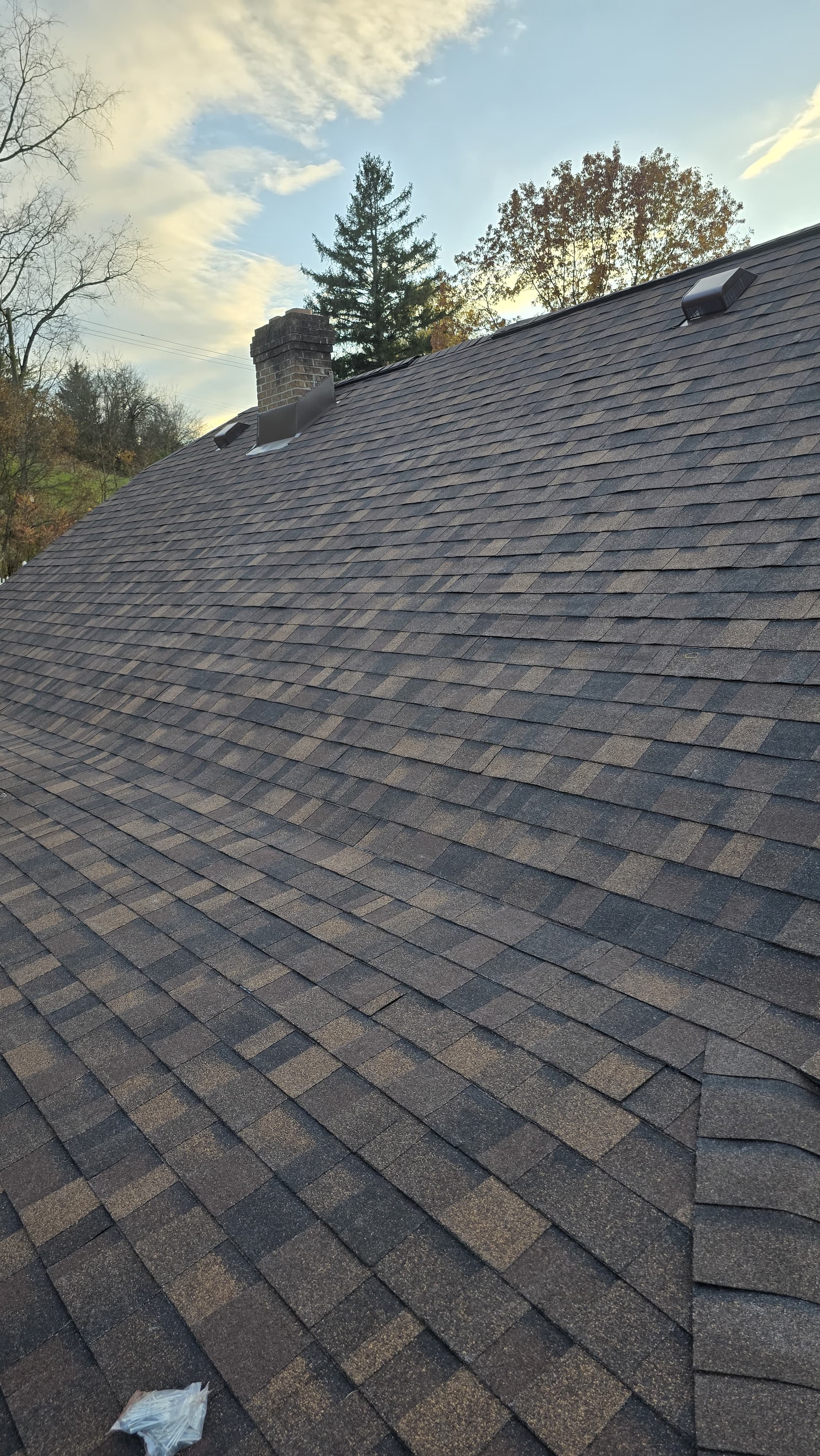 Ground-level view of completed re-roof with charcoal architectural shingles, Pittsburgh PA
